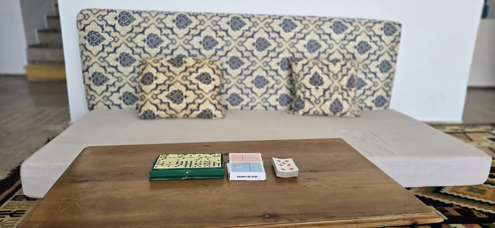 Banquette artisanale avec jeux de société, salon de la villa Dar Sekia