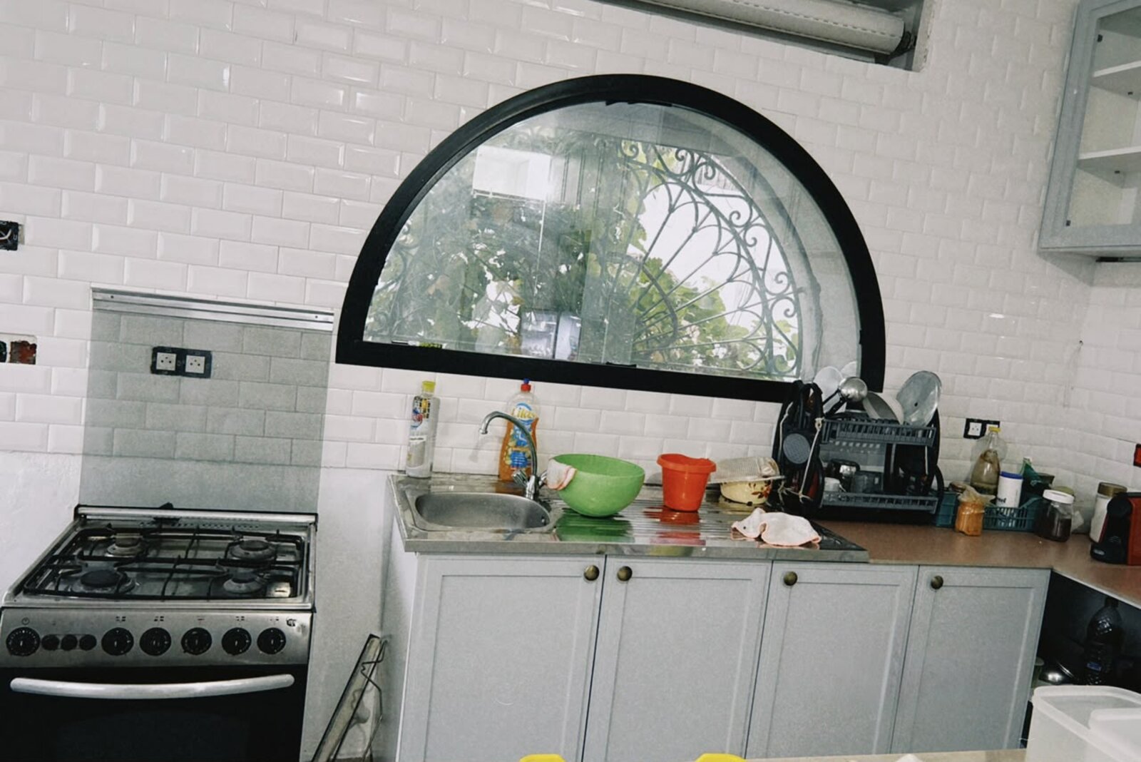 Coin évier et plaques de cuisson sous fenêtre arquée, cuisine villa Dar Sekia